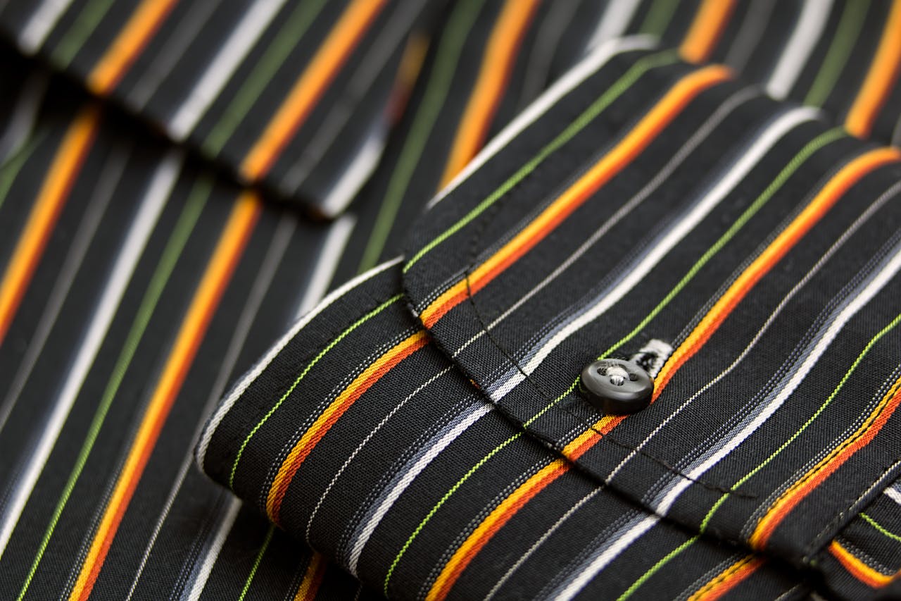 Macro shot showcasing the striped pattern and detailed texture of a mens dress shirt cuff.